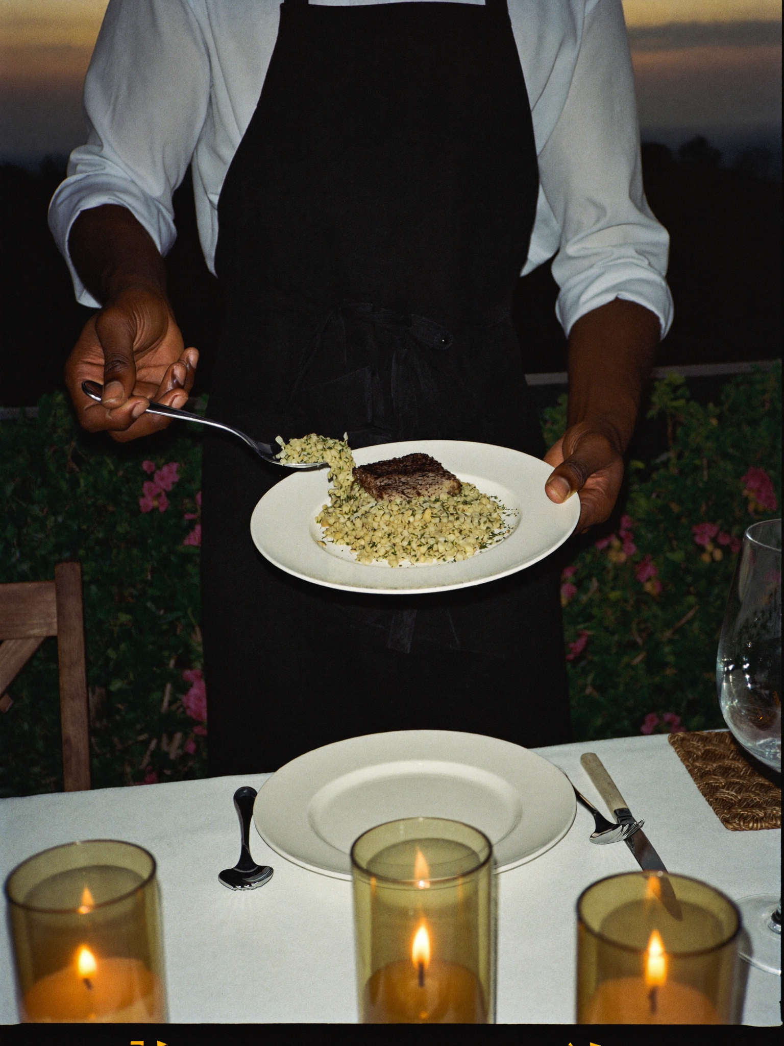 A private chef plating at a candlelit terrace table in Accra